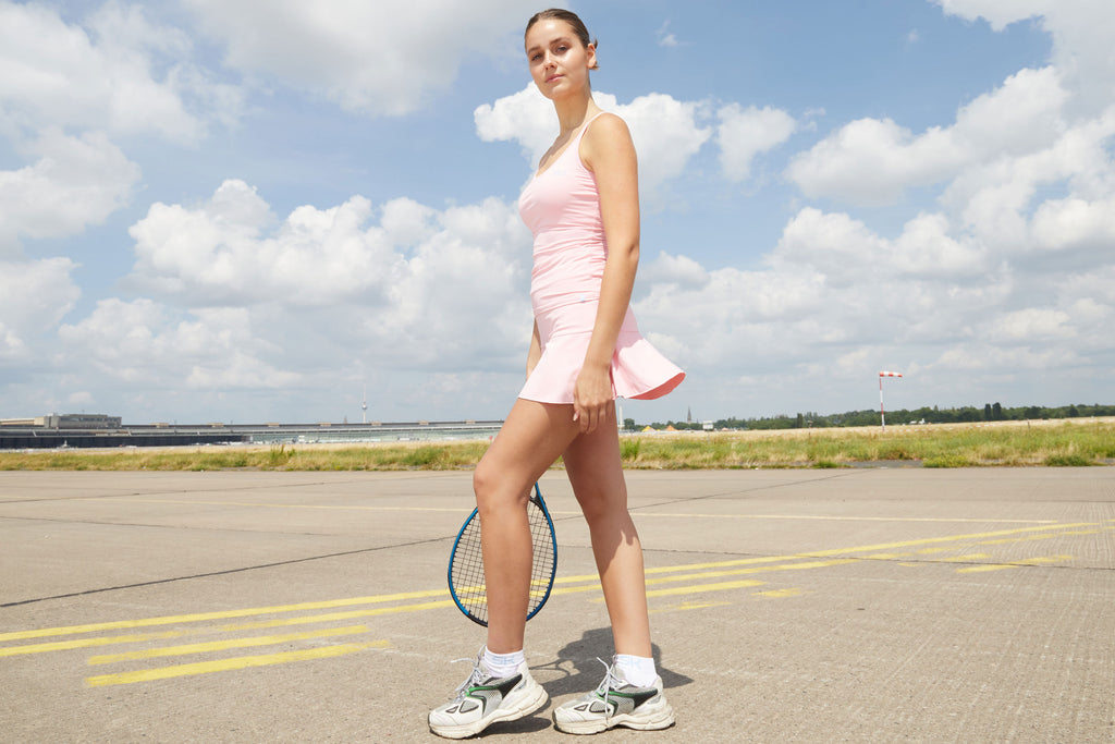 Dame mit hellrosa Tenniskleidung von Sportkind, bestehend aus glockigem Rock und Top